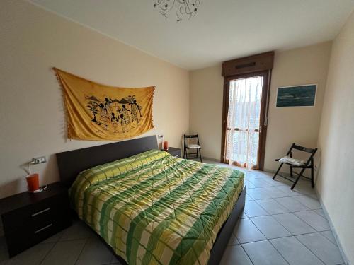 - une chambre dotée d'un lit avec une couverture verte et jaune dans l'établissement Casa Felice, à Argenta