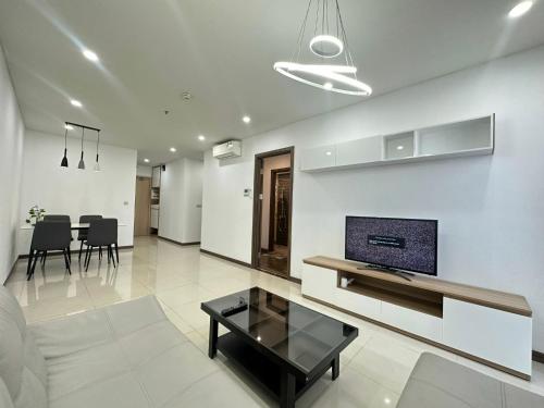 胡志明市的住宿－Qhome，客厅配有沙发和墙上的电视