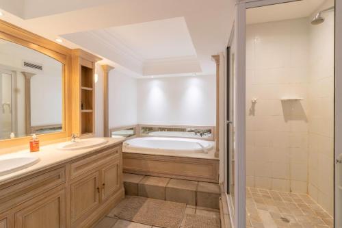 a bathroom with two sinks and a bath tub at Beachfront Seaview in Cape Town