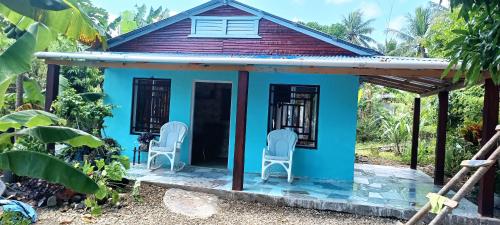 mały niebieski dom z krzesłami w ogrodzie w obiekcie Casa de campo w mieście Puerto Plata