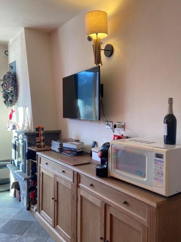 a microwave sitting on top of a counter with a tv at macalu 1 in Prato Nevoso