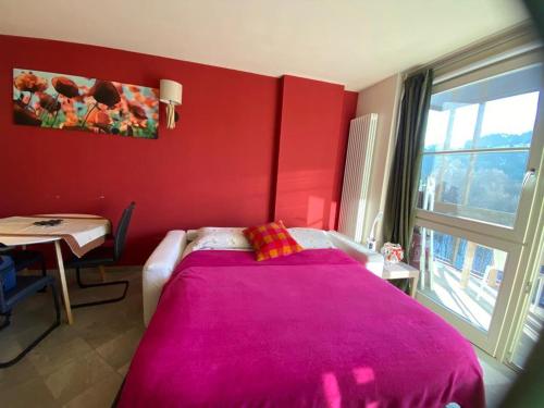 a red bedroom with a bed with a pink blanket at macalu 1 in Prato Nevoso