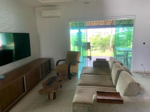 ein Wohnzimmer mit Sofa und Flachbildfernseher in der Unterkunft Casa no Sítio - Vovó Lalá in Cabo Frio