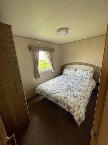a bedroom with a bed and a window at Breaks on the Lakes in Tattershall
