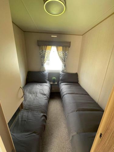 a small room with couches in a room with a window at Breaks on the Lakes in Tattershall