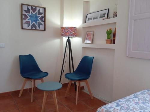 two blue chairs and a lamp in a bedroom at Hakuna Matata Hostel in Zambujeira do Mar