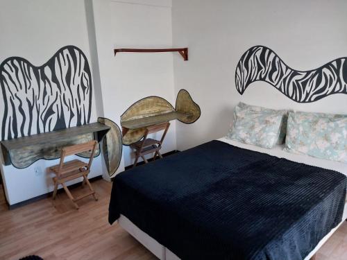 a bedroom with a bed and a piano and a desk at FrenteMar OuroVerde BetoCarrero in Navegantes