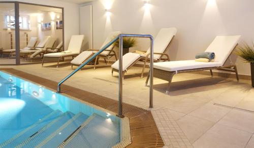 einen Pool mit Liegestühlen und einem Pool in der Unterkunft Inselresidenz Strandburg Juist Wohnung 309 Ref. 50976 in Juist