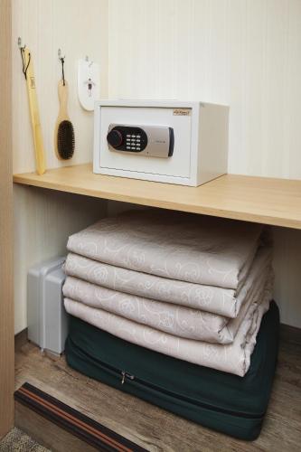 a microwave sitting on top of a shelf with towels at Savoy Hotel Myeongdong in Seoul