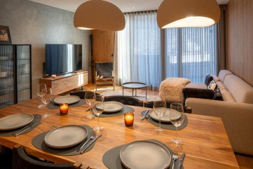 uma sala de estar com uma mesa de madeira e copos de vinho em Tarter Mountain & SPA em El Tarter