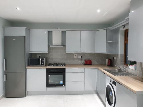 a kitchen with white cabinets and white appliances at Cozy Studio Apartment in Dublin