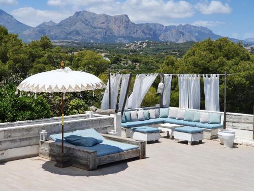 a patio with two couches and an umbrella at elparaiso-altea Luxury Apartment "CIELO" ADULTS ONLY Bed & Borrel in Altea