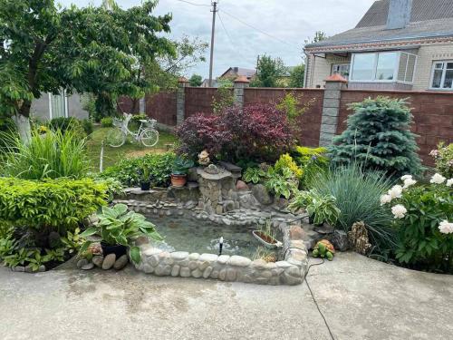 a garden with a small pond in the yard at Готель Алекс in Luts'k