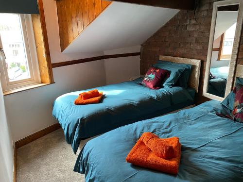um quarto com 2 camas com toalhas cor de laranja em Top O’ Th’ House . Hebden Bridge em Hebden Bridge