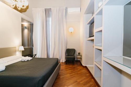 a bedroom with a bed and a chair in a room at Duomo Housing Catania Le Suites in Catania