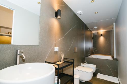 a bathroom with a sink and a toilet and a mirror at Duomo Housing Catania Le Suites in Catania