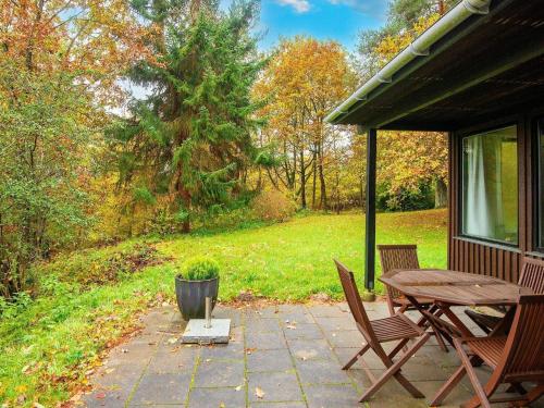 een patio met een houten tafel en 2 stoelen bij 4 person holiday home in Silkeborg in Silkeborg