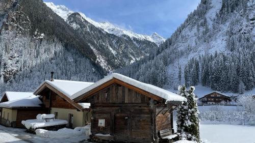 a cabin covered in snow in a mountain at Zillertal Residenz in Ginzling