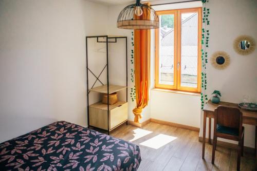une chambre avec un lit, un bureau et une fenêtre dans l'établissement Appartement à Taninges, à Taninges