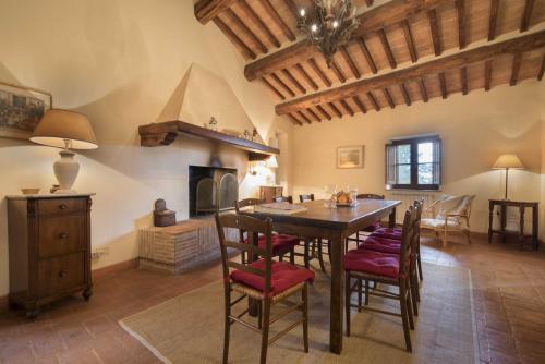 a kitchen with a table and chairs and a fireplace at Borgo di Camporsevoli in Camporsevoli