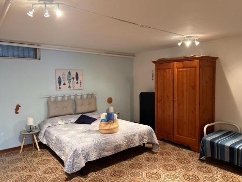 a bedroom with a bed and a wooden cabinet at Casa vacanze Marinella in Santo Stefano al Mare