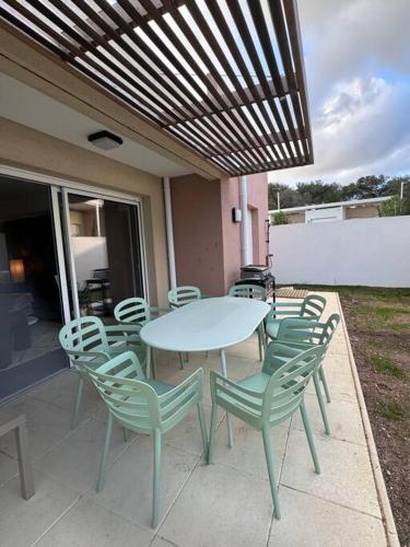 une table et des chaises assises sur une terrasse dans l'établissement Maison Joepolly corsica, à Bonifacio