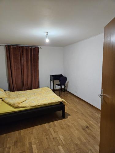 een slaapkamer met een bed en een stoel erin bij Standard room in La Chaux-de-Fonds