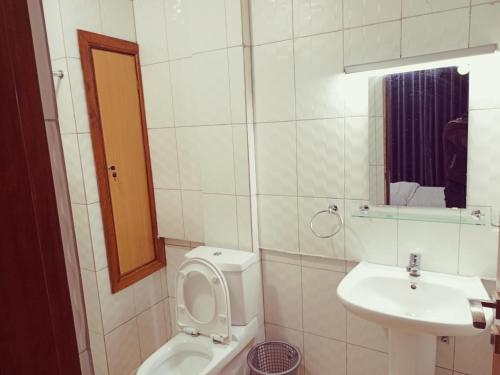 ein weißes Bad mit einem WC und einem Waschbecken in der Unterkunft Simon's Place in Kigali