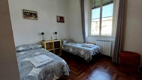 a small room with two beds and a window at Appartamento La Vecchia Ferrovia in Castellammare di Stabia