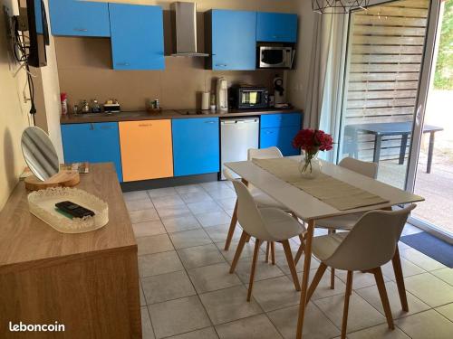 een keuken met blauwe kasten en een tafel en stoelen bij Vacances ou CNPE - Appart 2-3 pers - le Relais du Plessis - RICHELIEU in Chaveignes