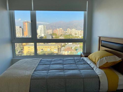 a bedroom with a bed and a large window at Departamento ñuñoa in Santiago