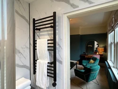 een kamer met een handdoekenrek en een stoel bij Baytree House in Harrogate