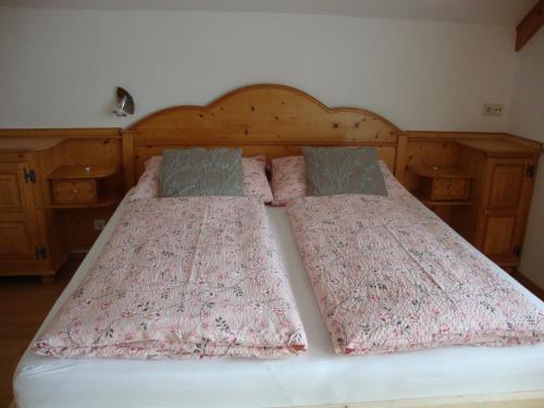 a large bed with two pillows on it at Apartment Haus Dengg in Mauterndorf