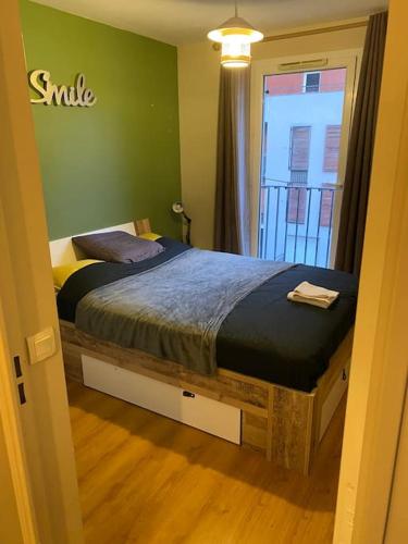 une chambre avec un lit dans une pièce avec une fenêtre dans l'établissement Appartement Stade de France, à Saint-Denis