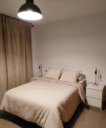- une chambre avec un grand lit blanc et une lampe dans l'établissement Piso en centro San Juan Alicante, à San Juan de Alicante