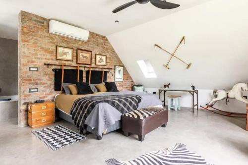 a bedroom with a bed and a brick wall at Chez ArtéKatz in Cape Town