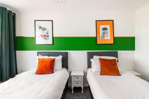 duas camas num quarto com verde e branco em Ark on the Hill em Chatham