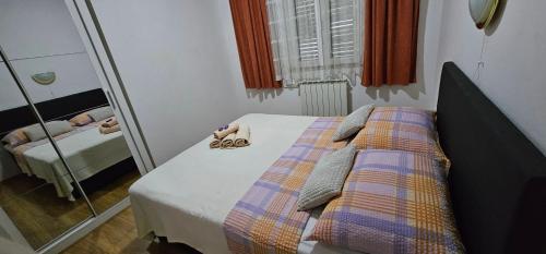 a small bedroom with a bed and a mirror at Apartman Pida in Primošten