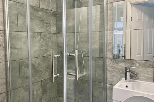 a bathroom with a glass shower with a sink at Ark on the Hill in Chatham