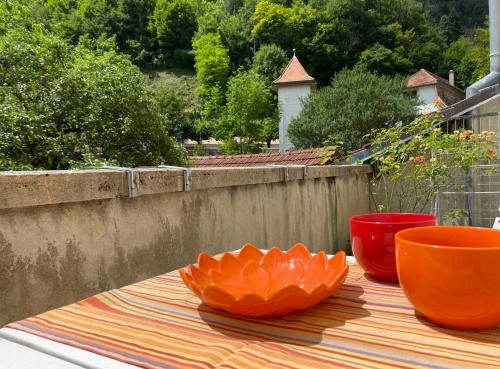 due ciotole arancioni sedute su un tavolo su un patio di Le Quartier 10 a Saint-Ursanne