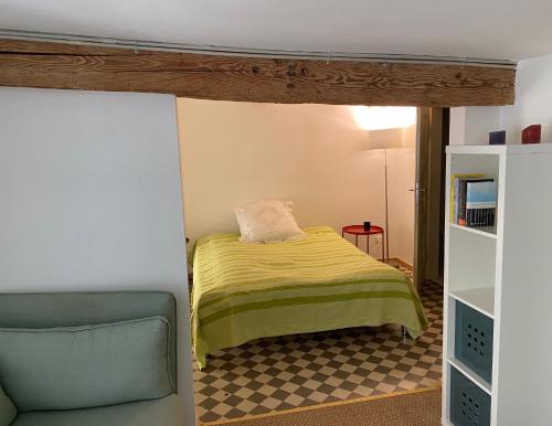 una piccola camera con letto e sedia di Le Quartier 10 a Saint-Ursanne