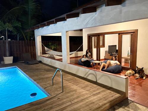 a group of people sitting on a couch next to a swimming pool at Villa Gabi - Blue Island in Punta Rucia