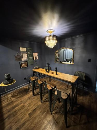uma sala de jantar com uma mesa e cadeiras e um lustre em Jay's Place on Archdale Light Rail em Charlotte