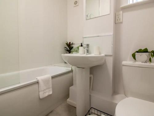 biała łazienka z umywalką i toaletą w obiekcie Pass the Keys Modern Minimalistic Apartment in City centre w mieście Newcastle upon Tyne