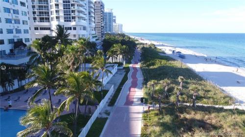 a view of a beach with palm trees and a building at Ocean Front Units at Miami Beach in Miami Beach