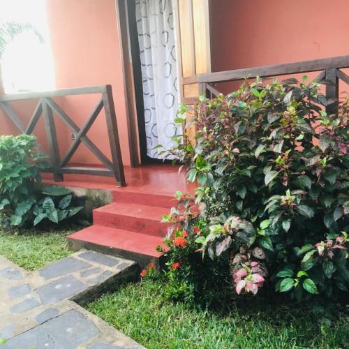 un escalier rouge menant à une maison avec une plante dans l'établissement Kylie, à Nosy Be