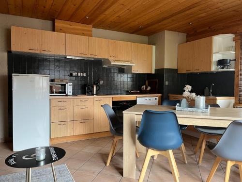 a kitchen with wooden cabinets and a table and chairs at Appartement LAPRESKI, spacieux, proximité d'Annecy, les Aravis in Thônes