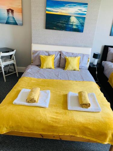 a large yellow bed with two towels on top of it at Cambois Elegance in Cambois