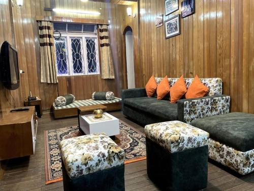 sala de estar con sofá, sillas y TV en The First House - 2 BHK in Main Gangtok en Gangtok
