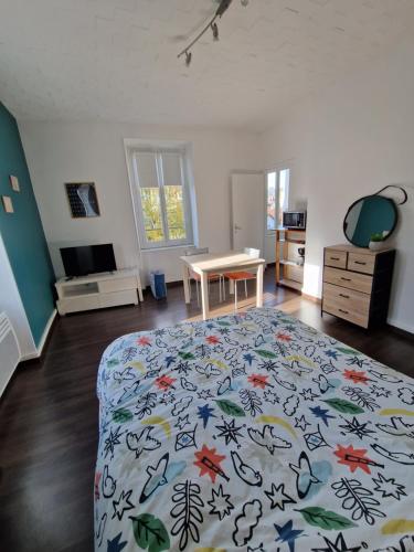 Un dormitorio con una cama y una mesa en una habitación. en Studio proche rectorat et théâtre de l'union, en Limoges